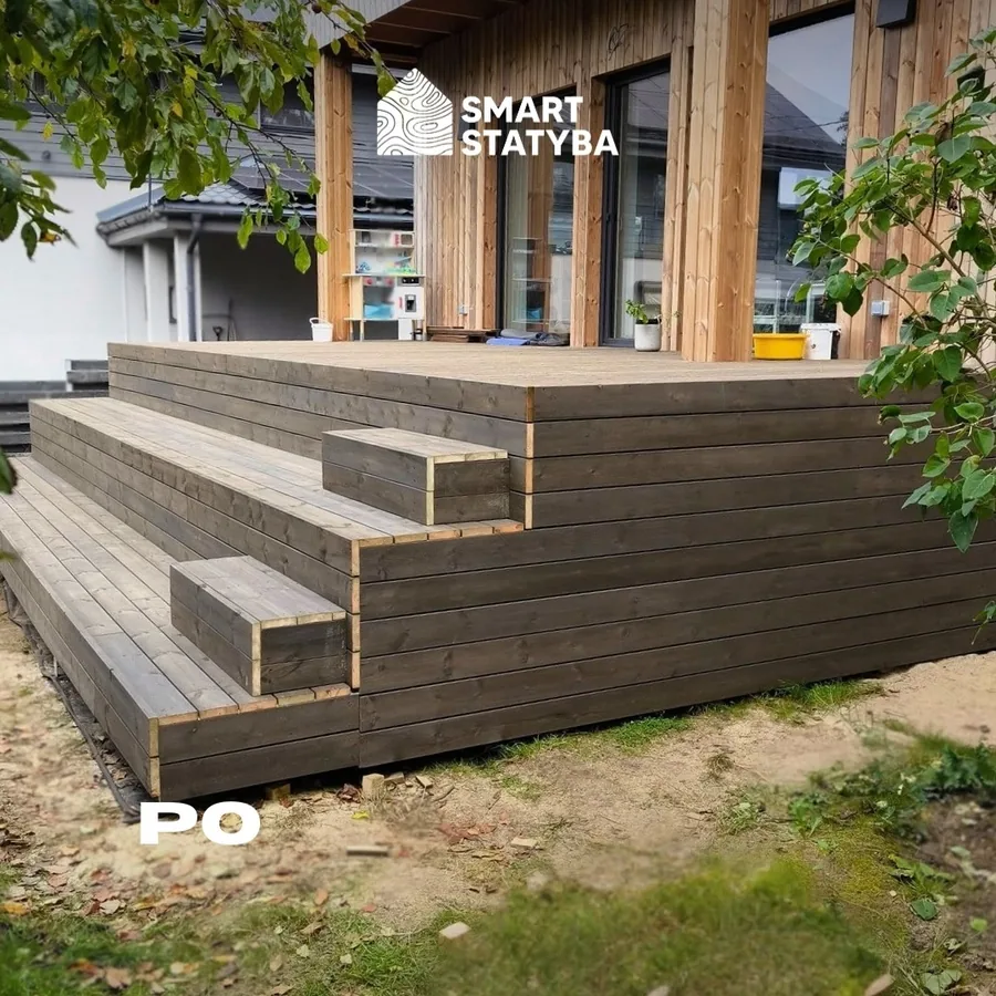 After: the finished wooden terrace with wide steps running along the same timber-clad house. Marked PO.